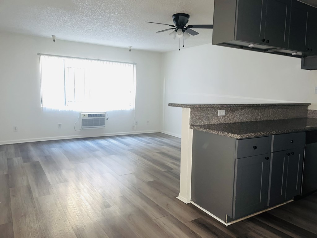 A room with a ceiling fan and a window with blinds.
