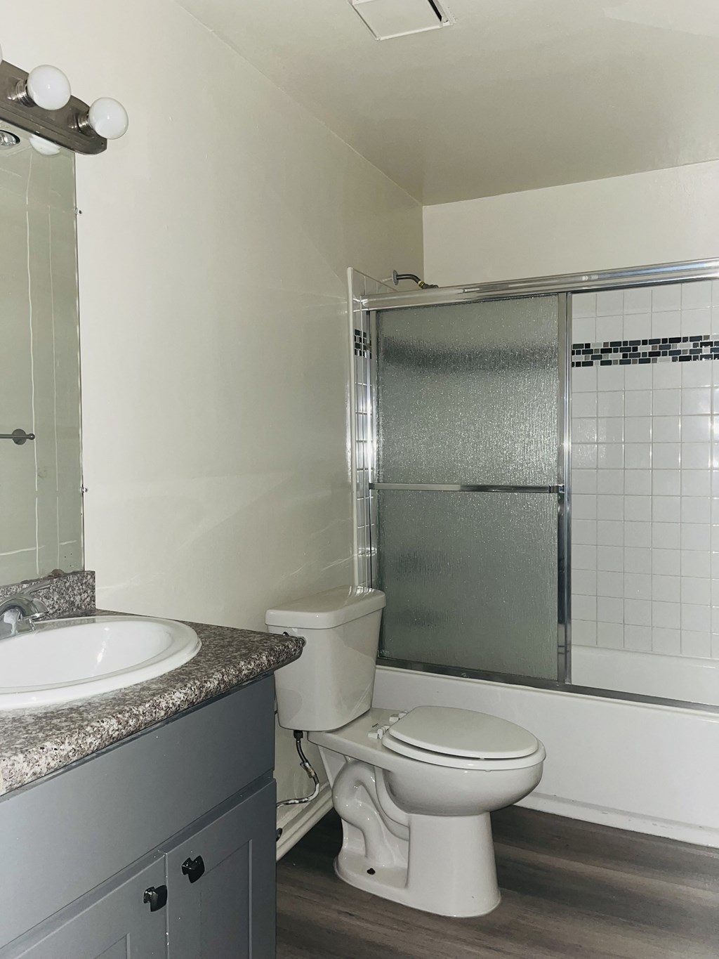 A bathroom with a toilet, sink, and shower.