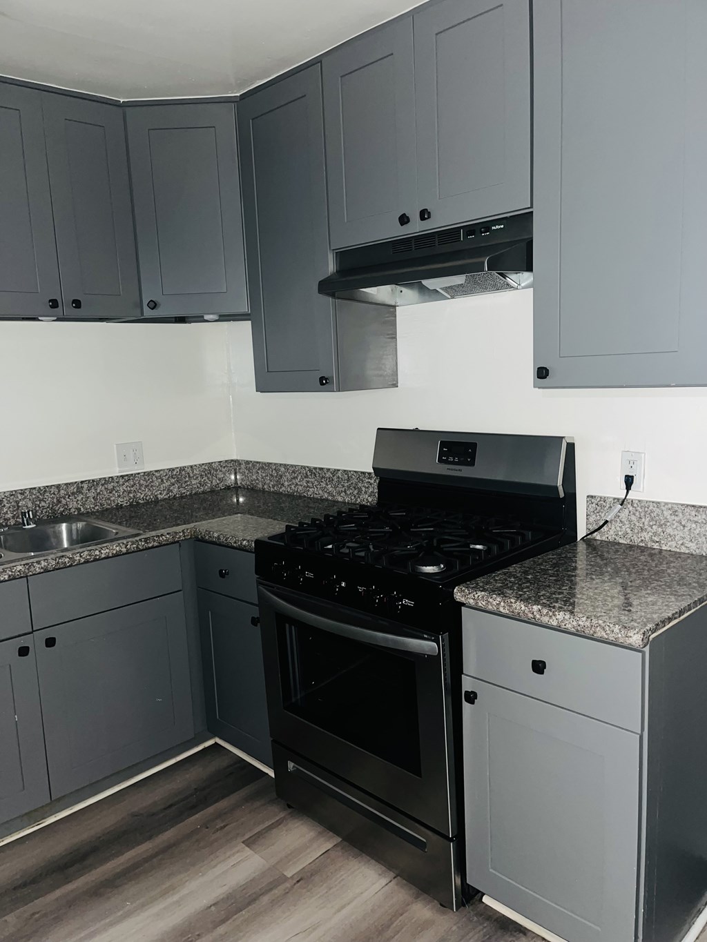 A kitchen with a black stove top oven and a black range hood.