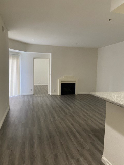 an empty living room with wood floors and a fireplace