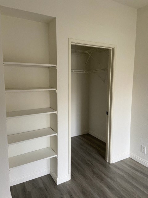 a walk in closet with empty shelves and a closet door