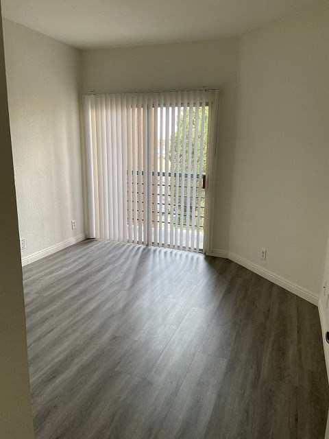 an empty living room with a sliding glass door to a balcony
