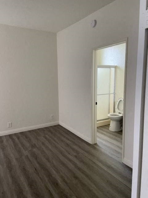 an empty room with a toilet and a door to a bathroom
