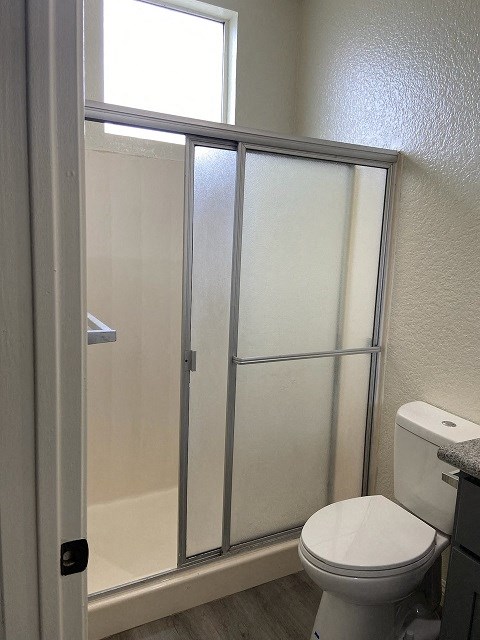 a bathroom with a toilet and a shower