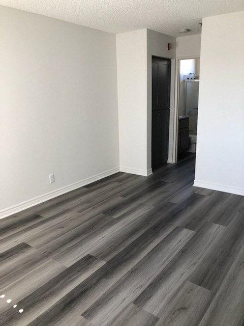 a renovated living room with white walls and wood floors