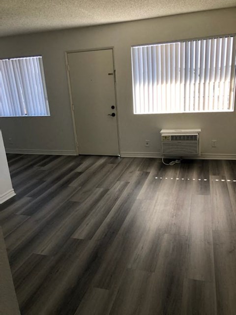 an empty room with wooden floors and a door