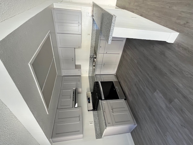 A white cabinet with a black drawer is in the center of the image.