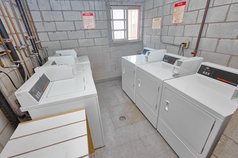 A room with two washing machines and a window.