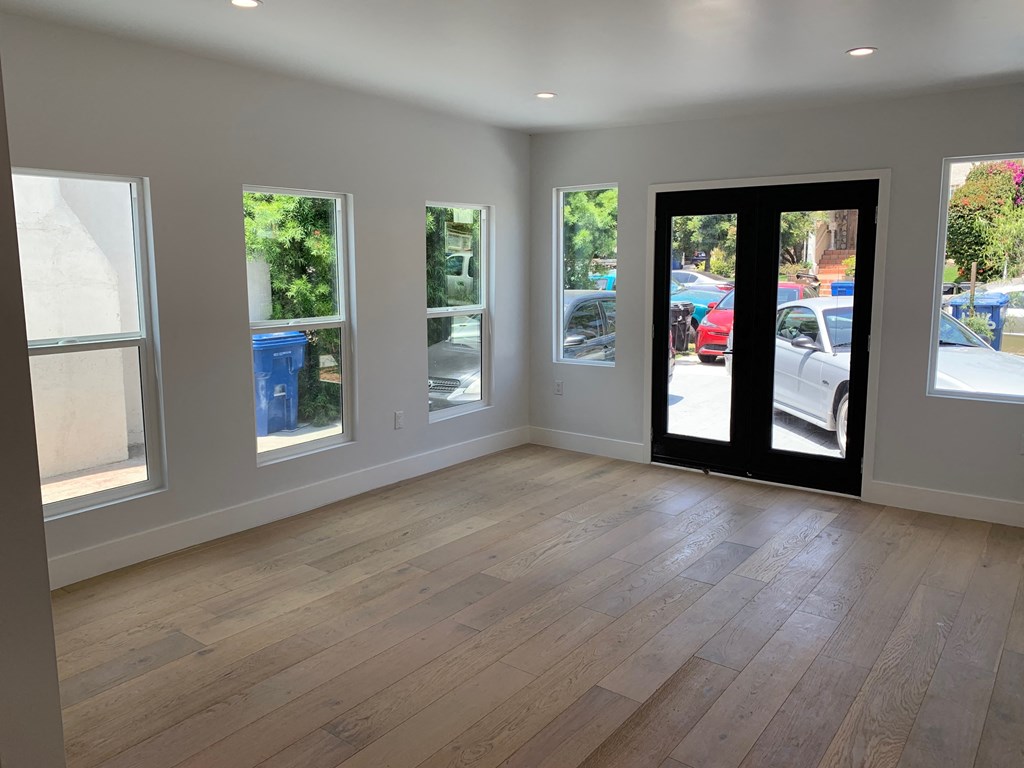 an empty living room with a wood floor and a door