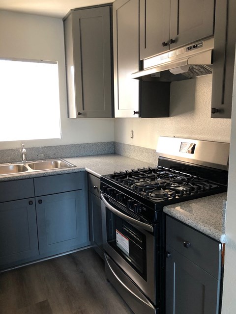 an empty kitchen with a stove and a sink