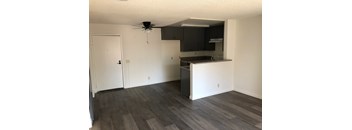 A kitchen with a black countertop and a ceiling fan.