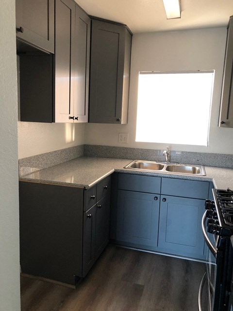 an empty kitchen with blue cabinets and a sink