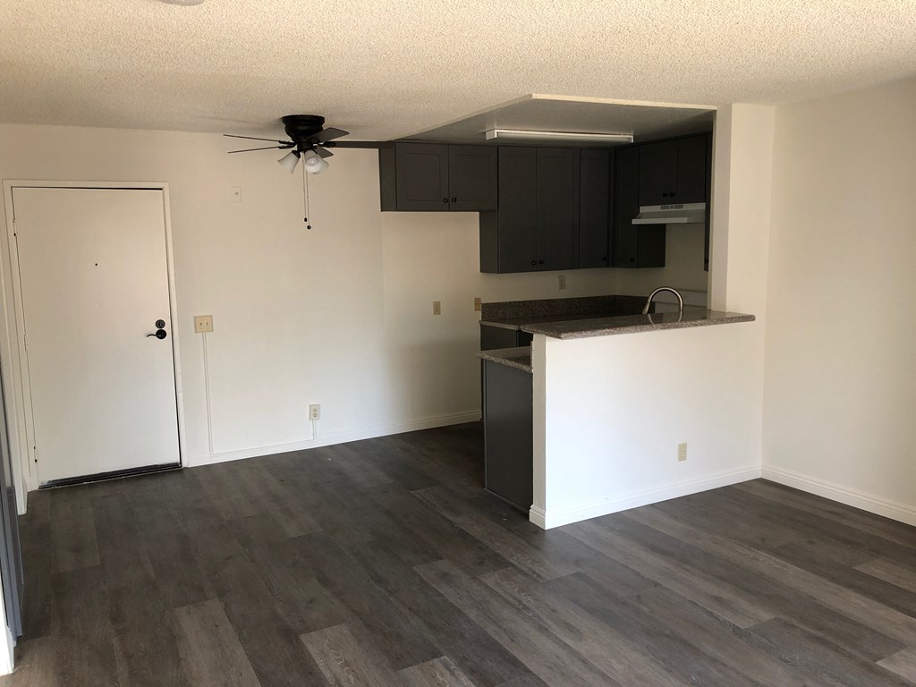 an empty kitchen with white walls and black cabinets