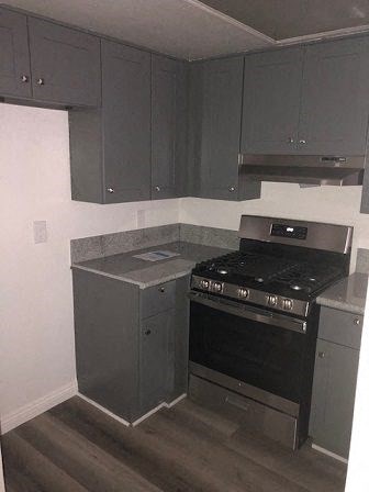 an empty kitchen with a stove and cabinets