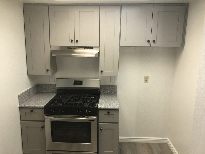 a kitchen with a stove and white cabinets