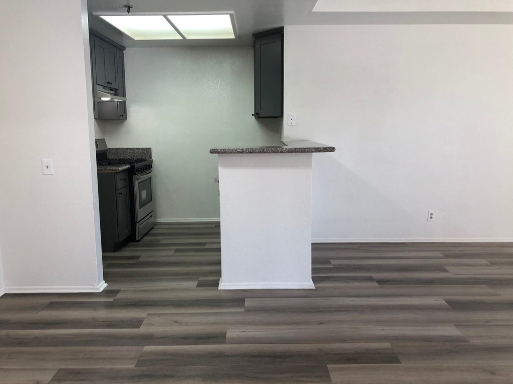 a living room with a white pillar and wood flooring