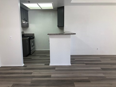 a living room with a white pillar and wood flooring