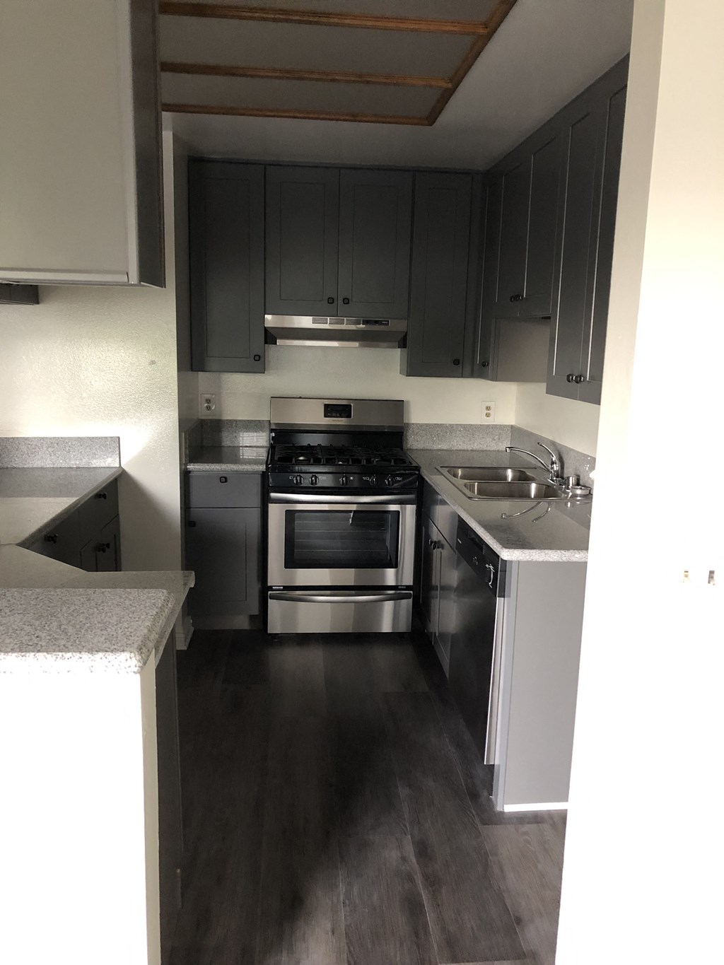 an empty kitchen with stainless steel appliances and black cabinets