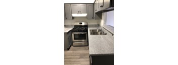 A kitchen with a stove, oven, and sink.