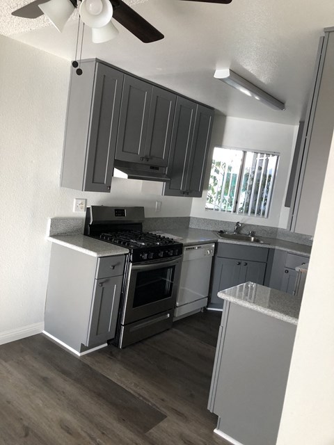 a small kitchen with gray cabinets and stainless steel appliances