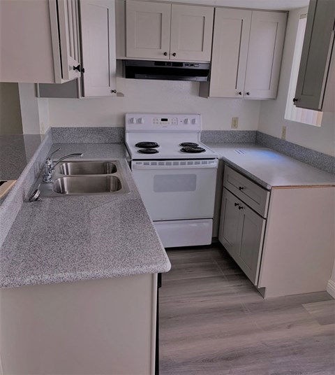 a kitchen with white appliances and gray counter tops
