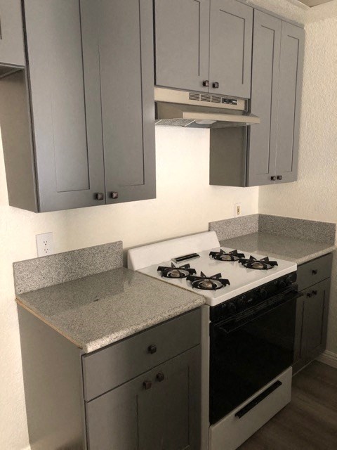 an empty kitchen with a stove and cabinets