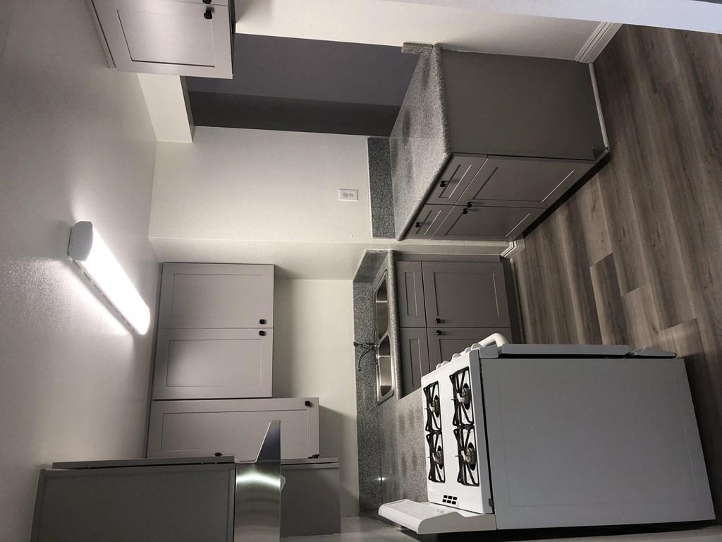 a view from the top of a room into a hallway with cabinets and a staircase