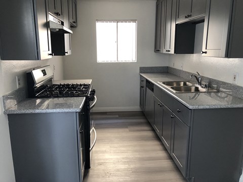 an empty kitchen with stainless steel counters and a sink
