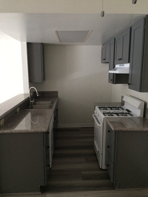 an empty kitchen with a stove and a sink