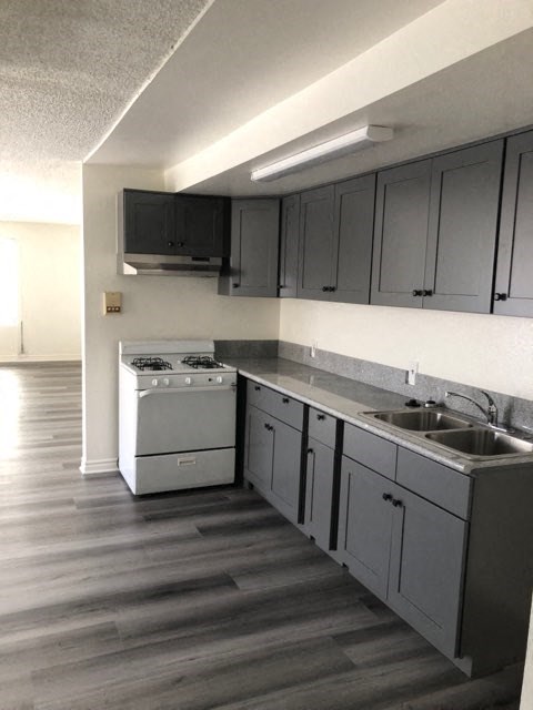 an empty kitchen with a stove and a sink