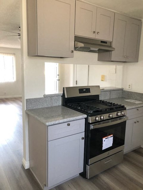 a kitchen with a stove and white cabinets