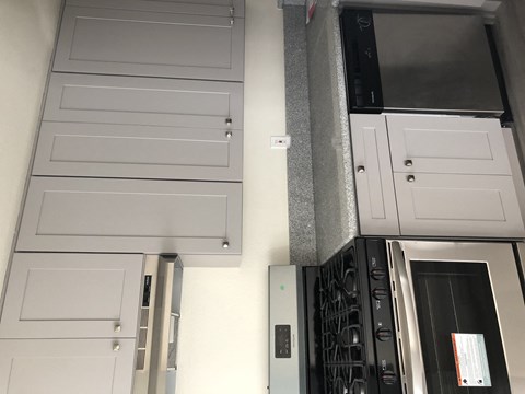 a kitchen with white cabinets and a stove and a refrigerator
