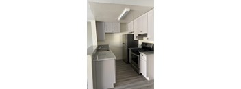 A kitchen with a sink, stove, and refrigerator.