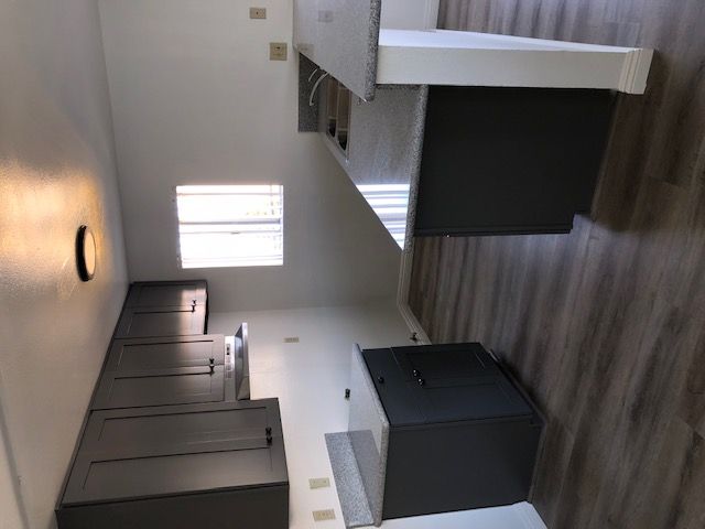 A room with a row of beds and a black box on the floor.