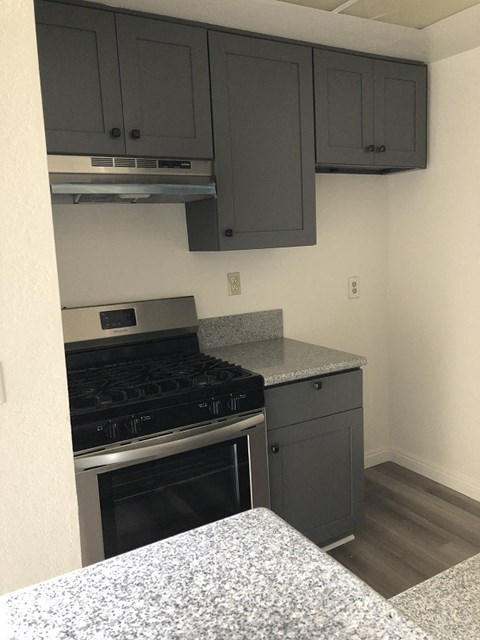 an empty kitchen with a stove and cabinets