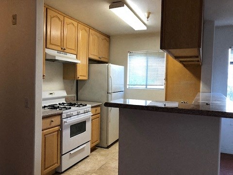 a kitchen with white appliances and wooden cabinets