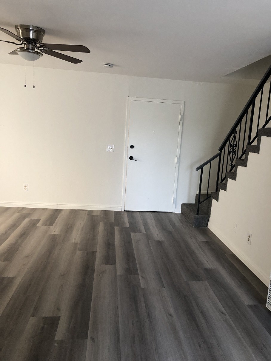 an empty living room with hardwood floors and a staircase