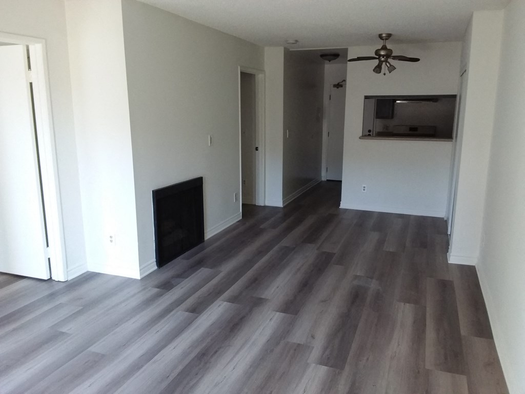 a renovated living room with hardwood floors and a fireplace