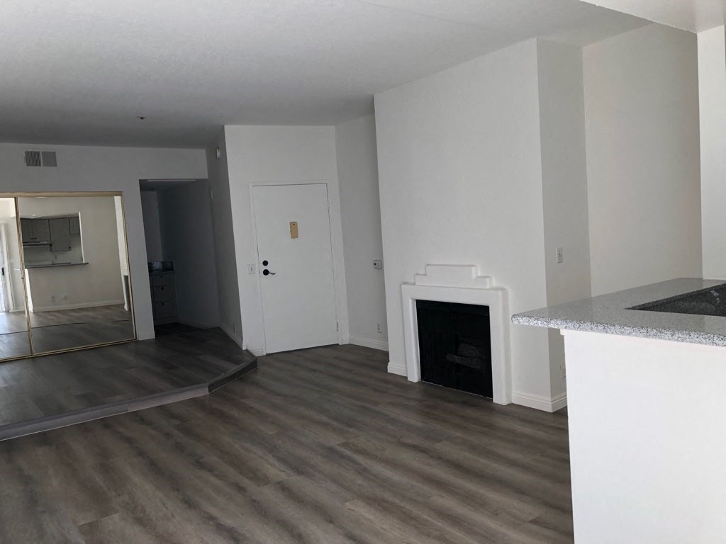 a living room with white walls and a fireplace