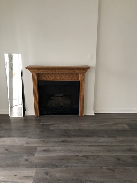 a living room with a fireplace and wooden floors