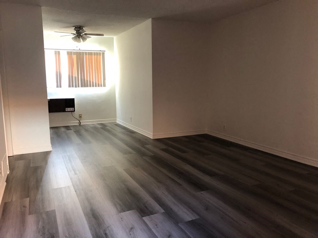 a living room with wooden floors and a ceiling fan