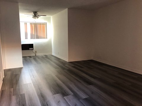 a living room with wooden floors and a ceiling fan