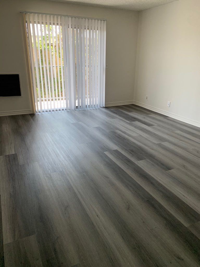 a living room with a wood floor and a sliding glass door