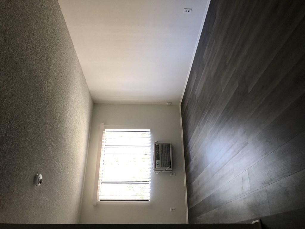 a small room with a window and a speaker on the wall