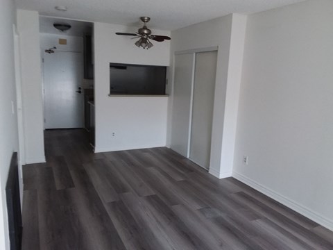 a renovated living room with wood floors and a ceiling fan