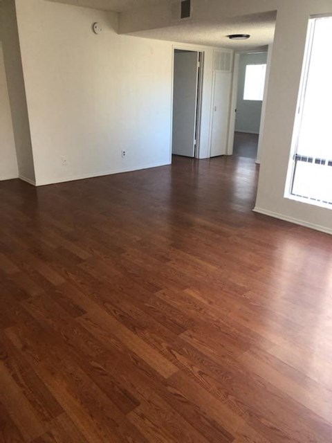 an empty living room with a wooden floor