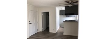 A room with a ceiling fan and a doorway leading to another room.