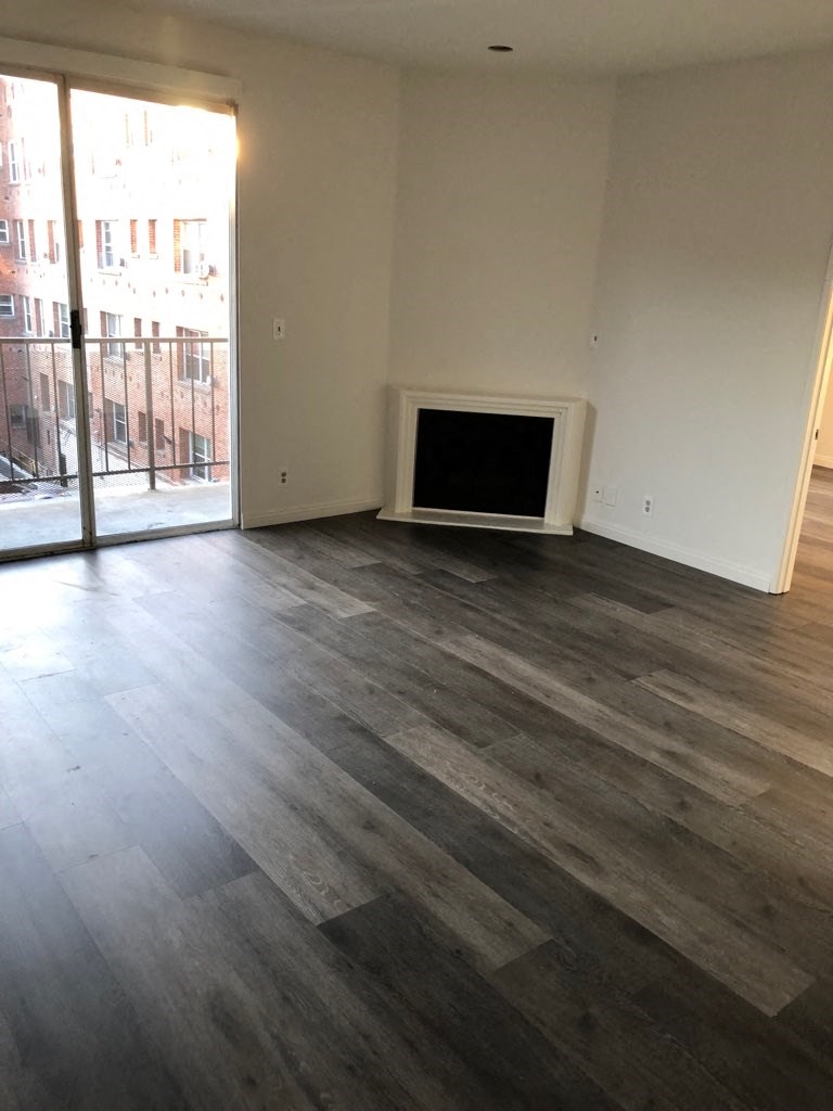 a living room with wood flooring and a fireplace