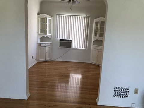 an empty living room with wooden floors and a window