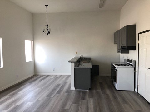 an empty kitchen with white cabinets and a stove and a refrigerator
